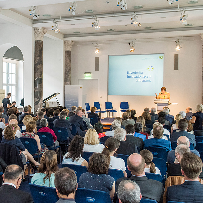 Die Teilnehmenden der Veranstaltung zum Bayerischen Innovationspreis Ehrenamt 2016 sitzen in einem Saal.